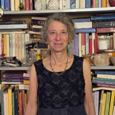 Zelda S. Zanobini, autrice del commento critico su Stefano Strazzabosco, ritratta davanti a una libreria colma di volumi.