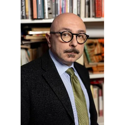 Ritratto del musicologo Carlo Fiore, autore del saggio La musica dei cattivi, in una biblioteca