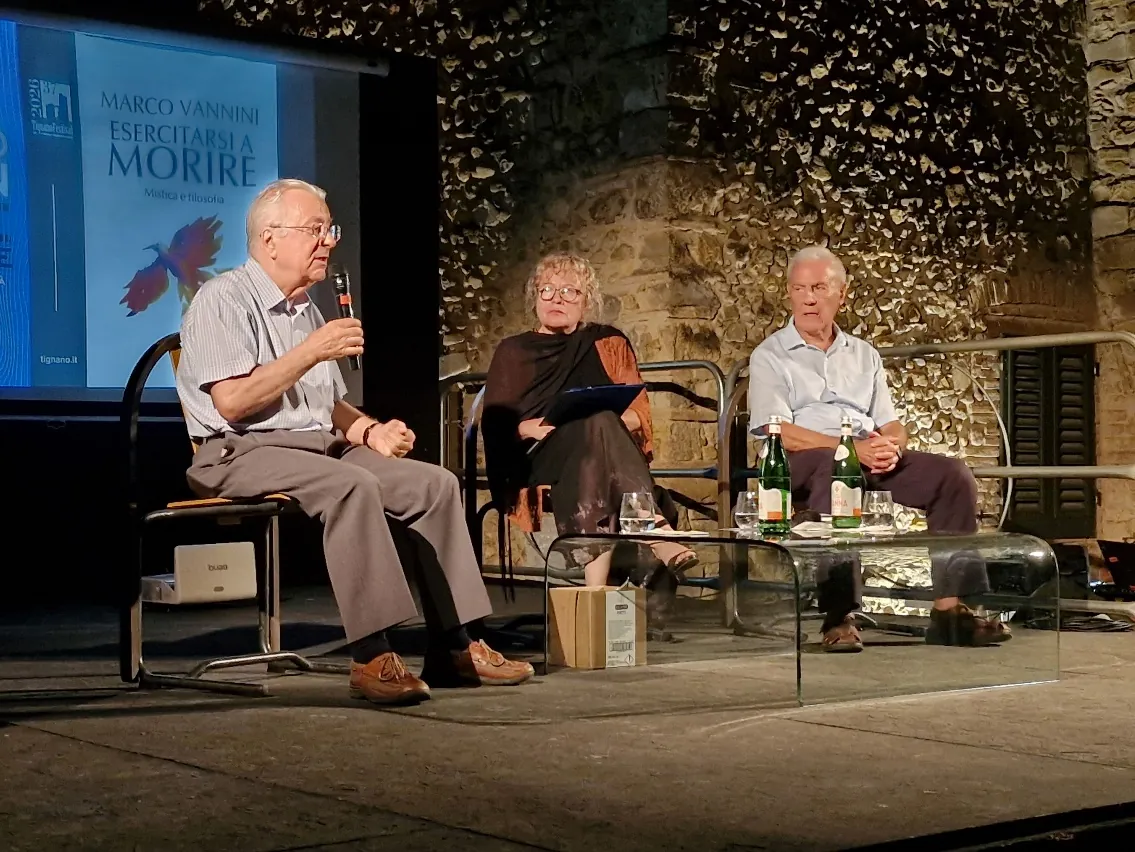 Il fisico e inventore Federico Faggin durante il suo intervento al Tignano Festival, seduto sul palco durante un dibattito su coscienza e tecnologia.